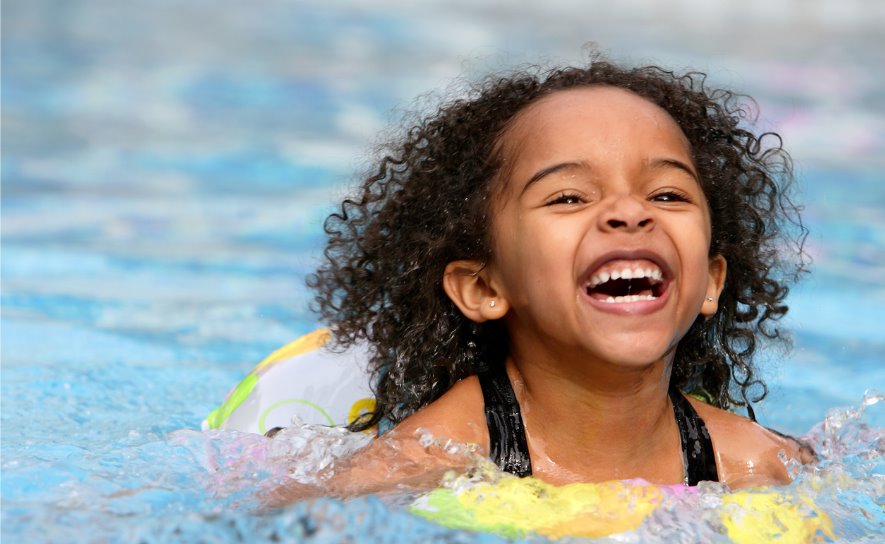 jubilant-kid-swimming-in-a-pool-picture-id147038986